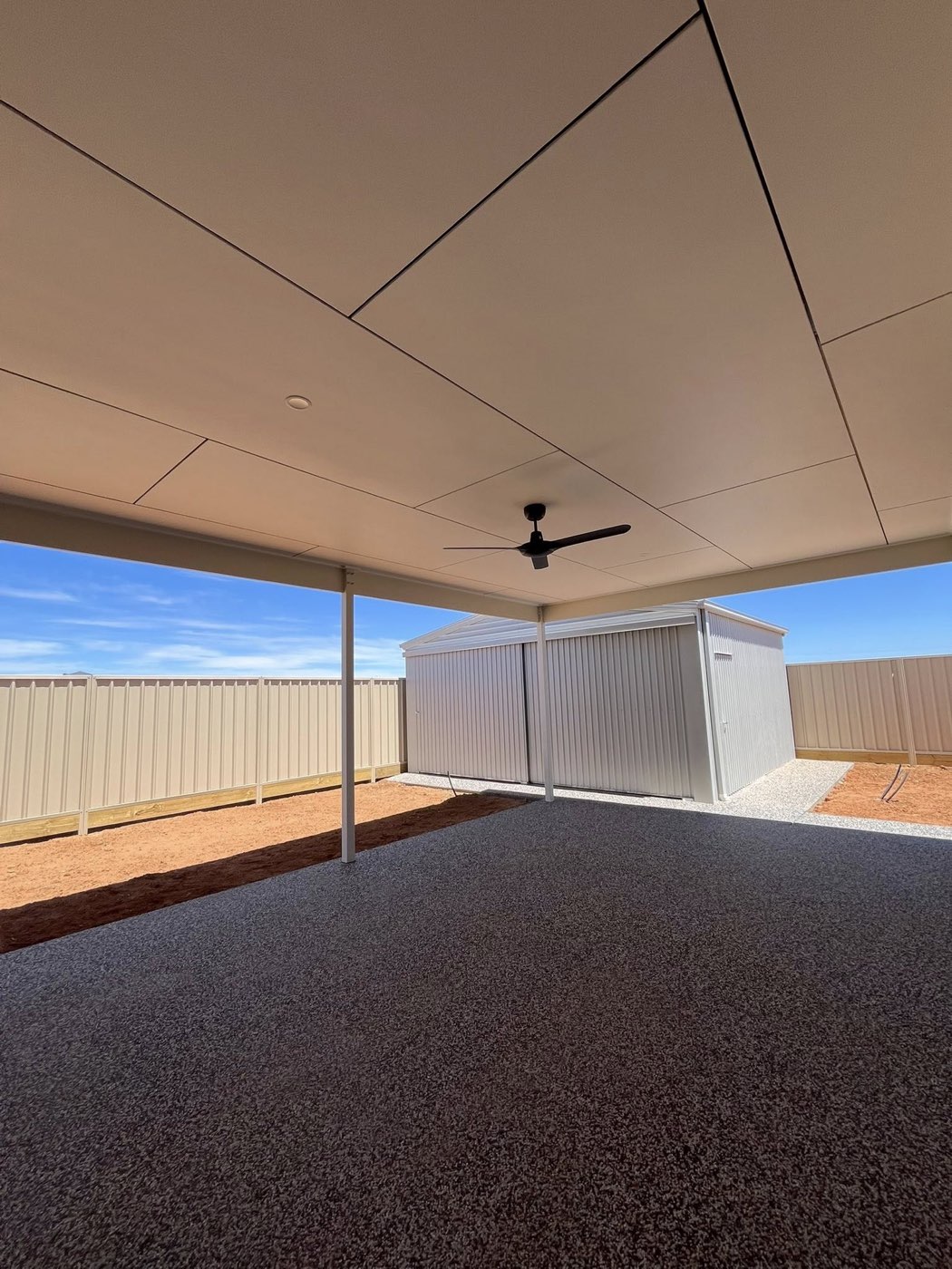 Alfresco area with ceiling fan looking out to backyard shed