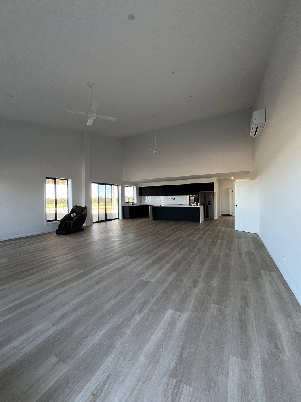 Open-plan living room with vaulted ceiling and LVP flooring