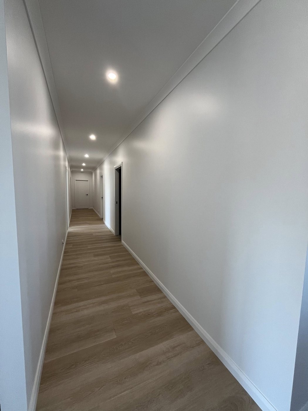 Hallway with timber flooring and downlights