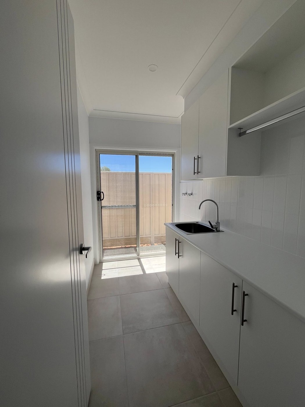 White laundry room with sliding door access
