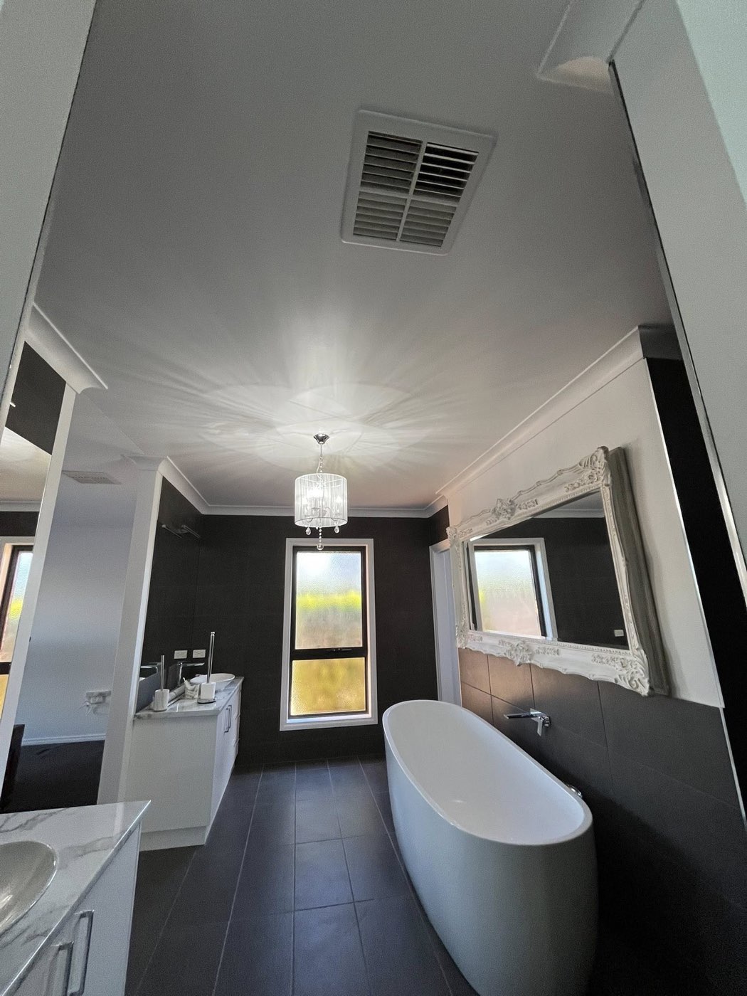 Bathroom with freestanding tub and ornate framed mirror