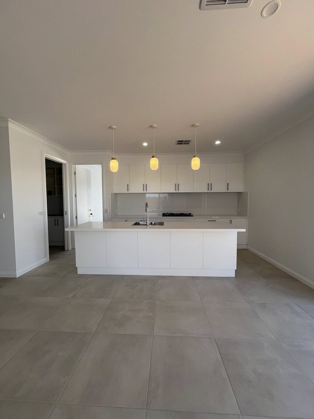 New kitchen with white cabinetry and tiled floor