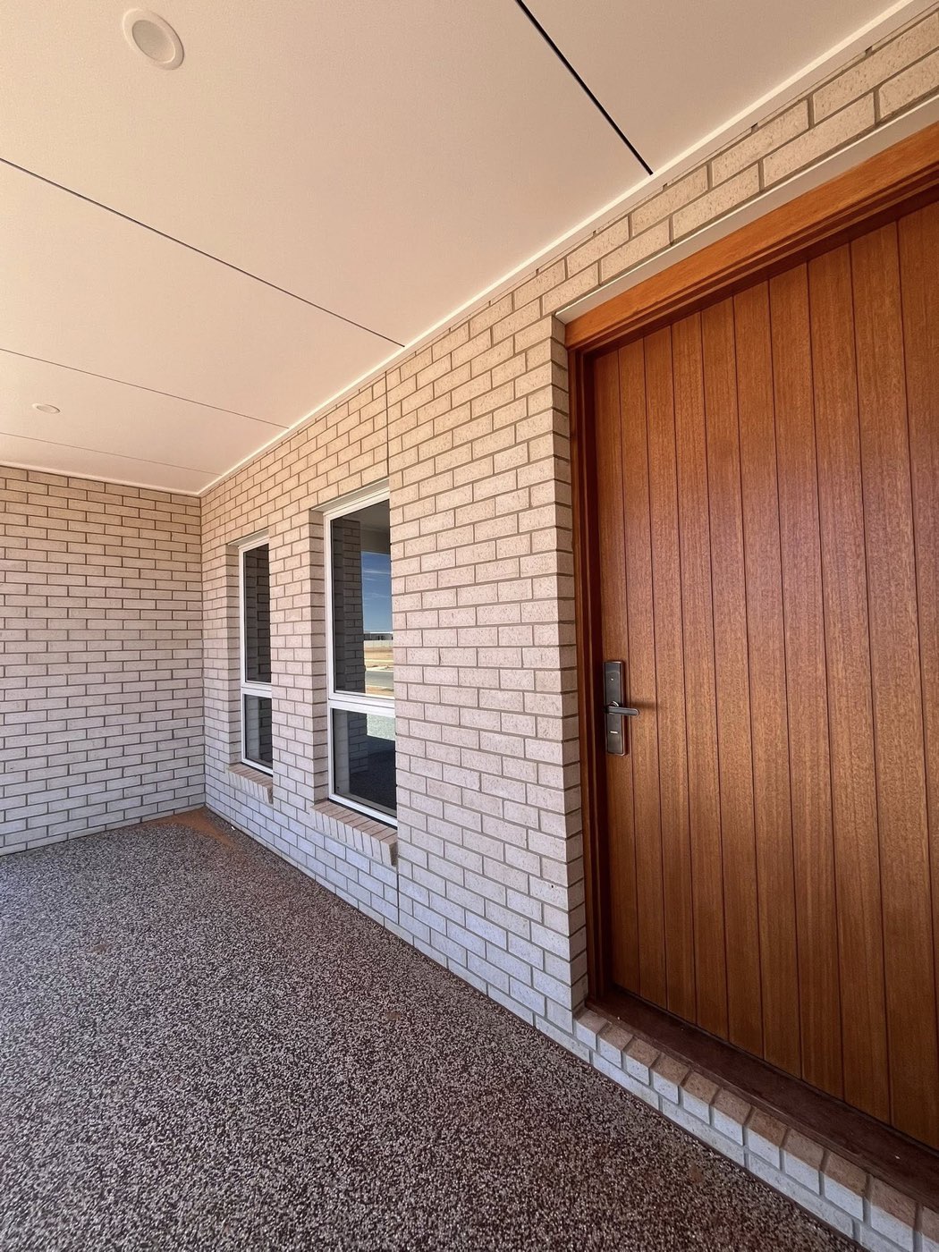 Front entry with stained timber door and pale brick