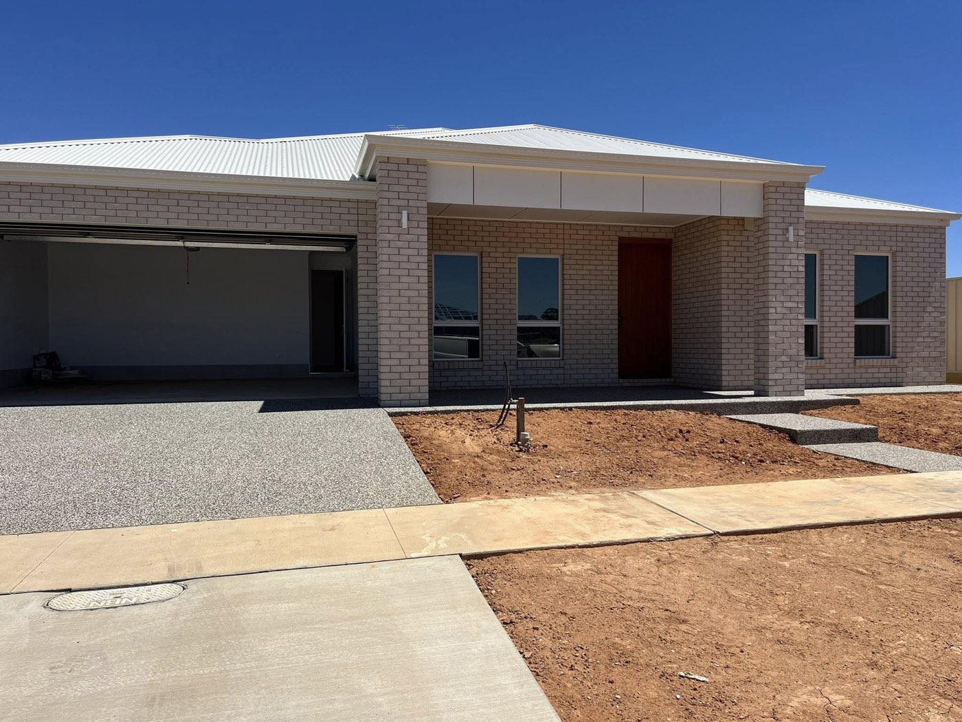 New brick home exterior with feature timber door