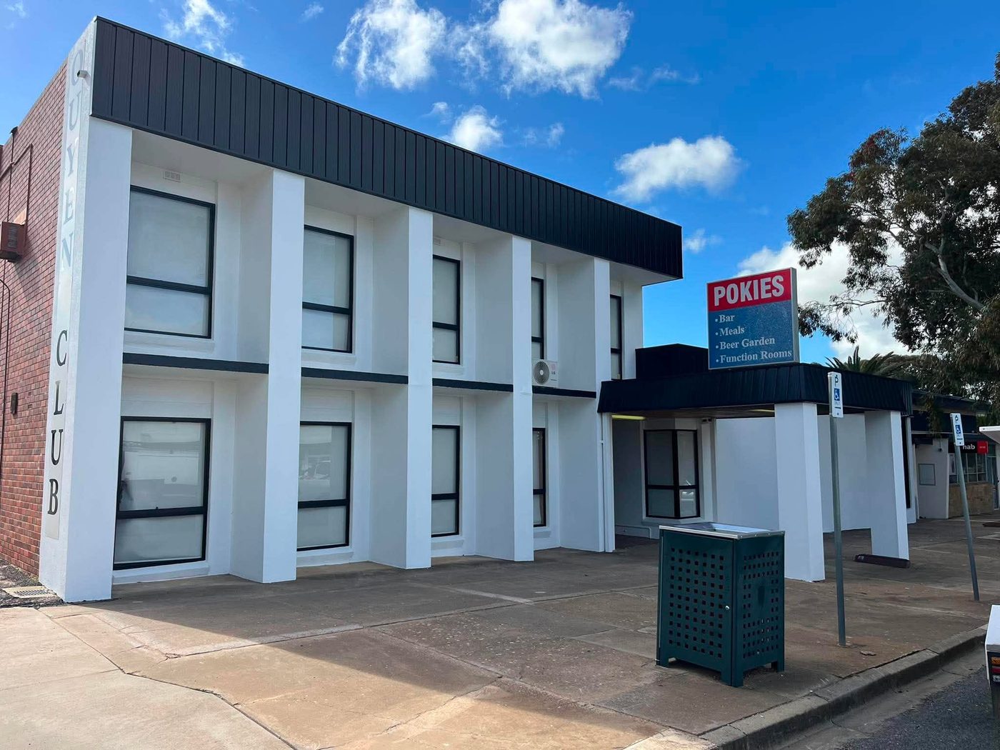 Ouyen Club facade after repaint — crisp white render with charcoal trim under blue sky
