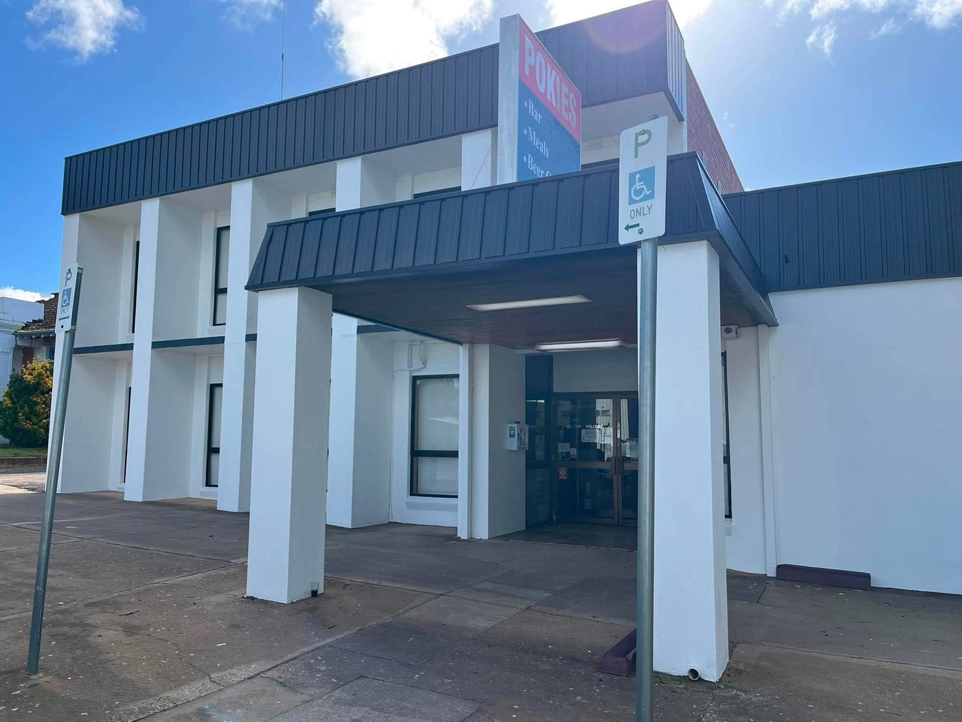 Ouyen Club visitor entrance after repaint — fresh white columns and charcoal canopy